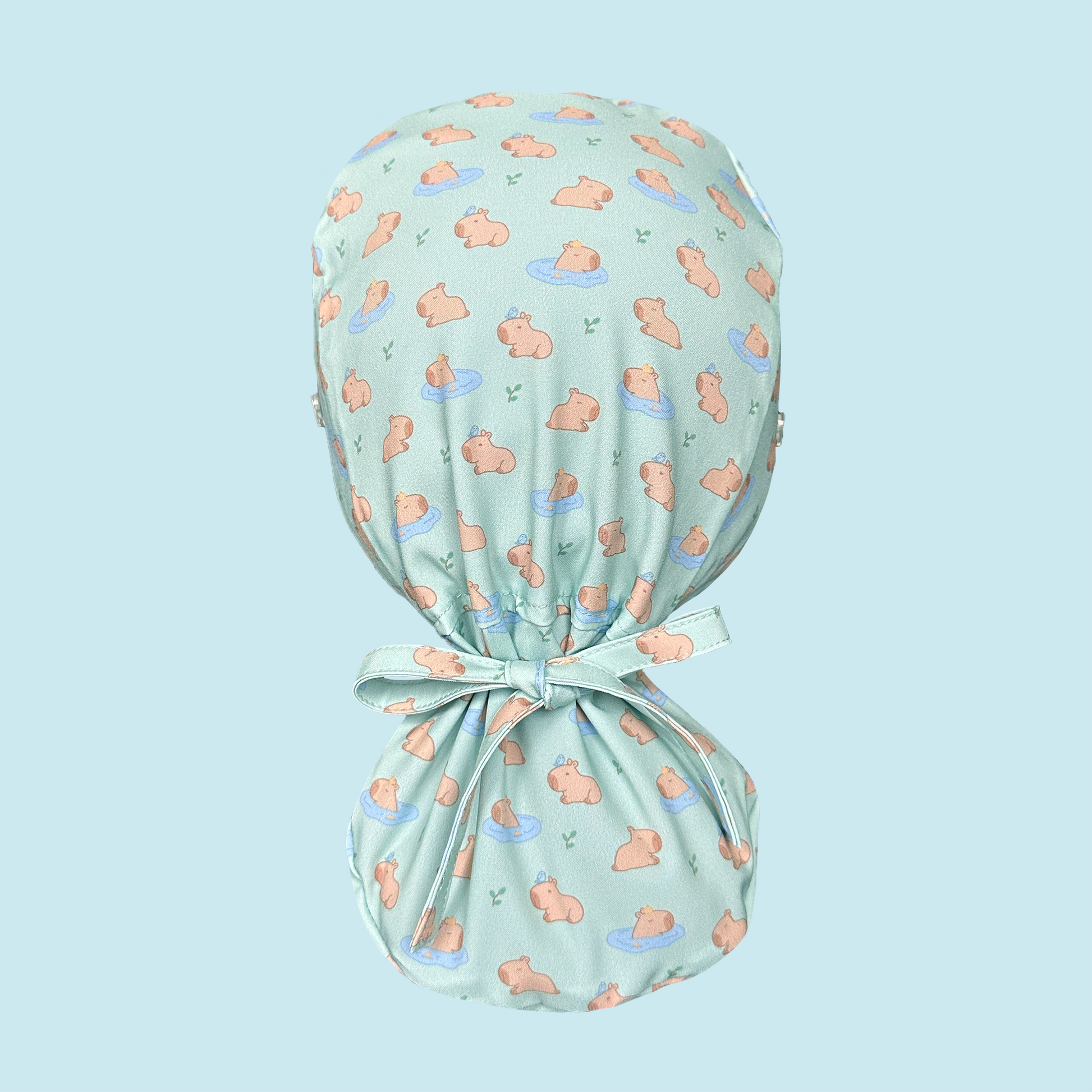 Rear view of light green scrub cap featuring capybaras