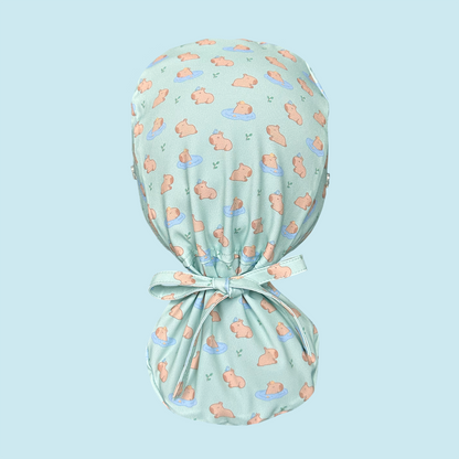 Rear view of light green scrub cap featuring capybaras