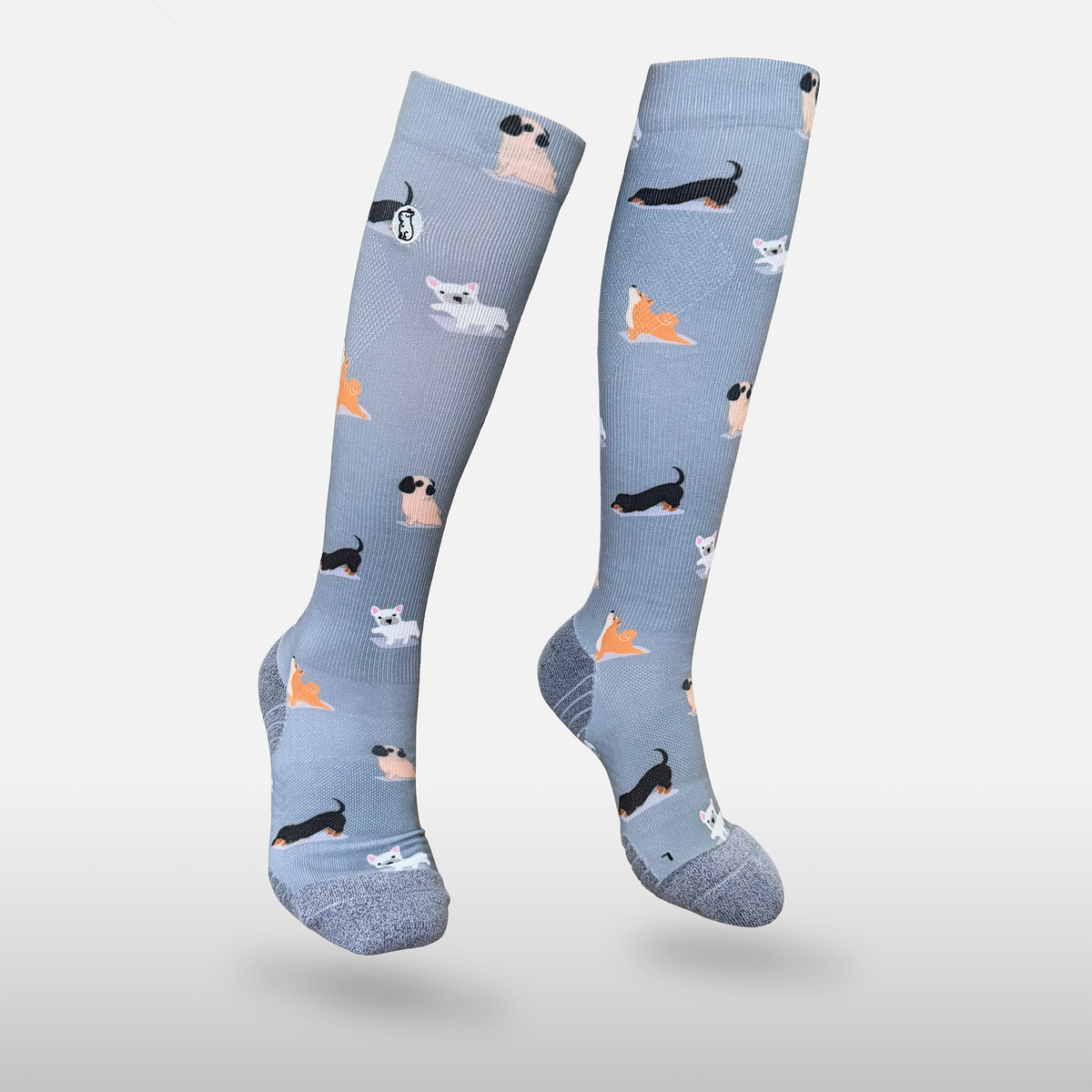 Floating blue/purple compression sock with print featuring various dogs on light grey background
