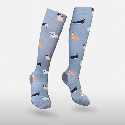 Floating blue/purple compression sock with print featuring various dogs on light grey background