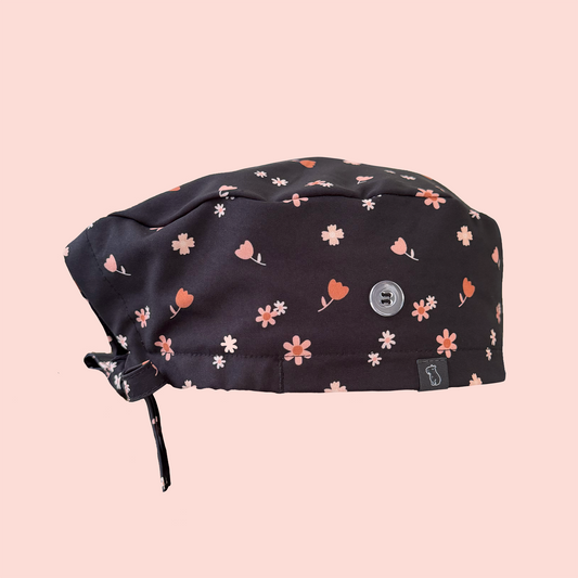 Side view of classic scrub cap featuring pink/peach flowers on a charcoal background