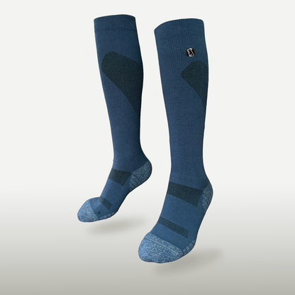 Floating navy blue compression sock with light blue toe and heel on light grey background