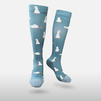Floating blue/teal compression sock with print featuring various ducks on light grey background