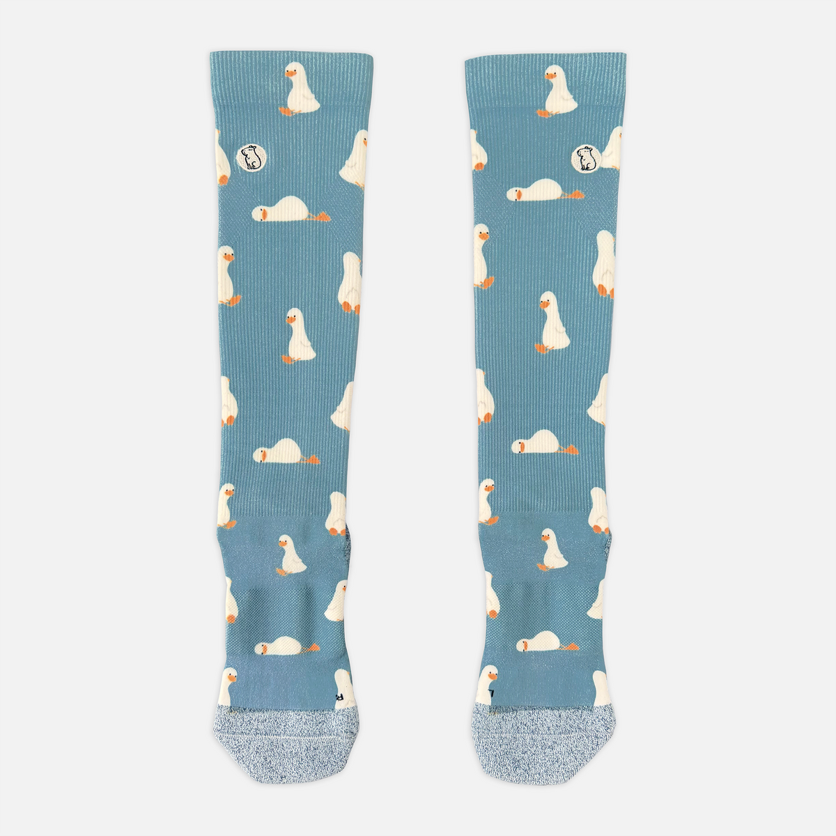 blue/teal compression sock with print featuring various ducks on light grey background
