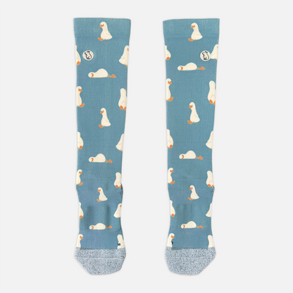 blue/teal compression sock with print featuring various ducks on light grey background